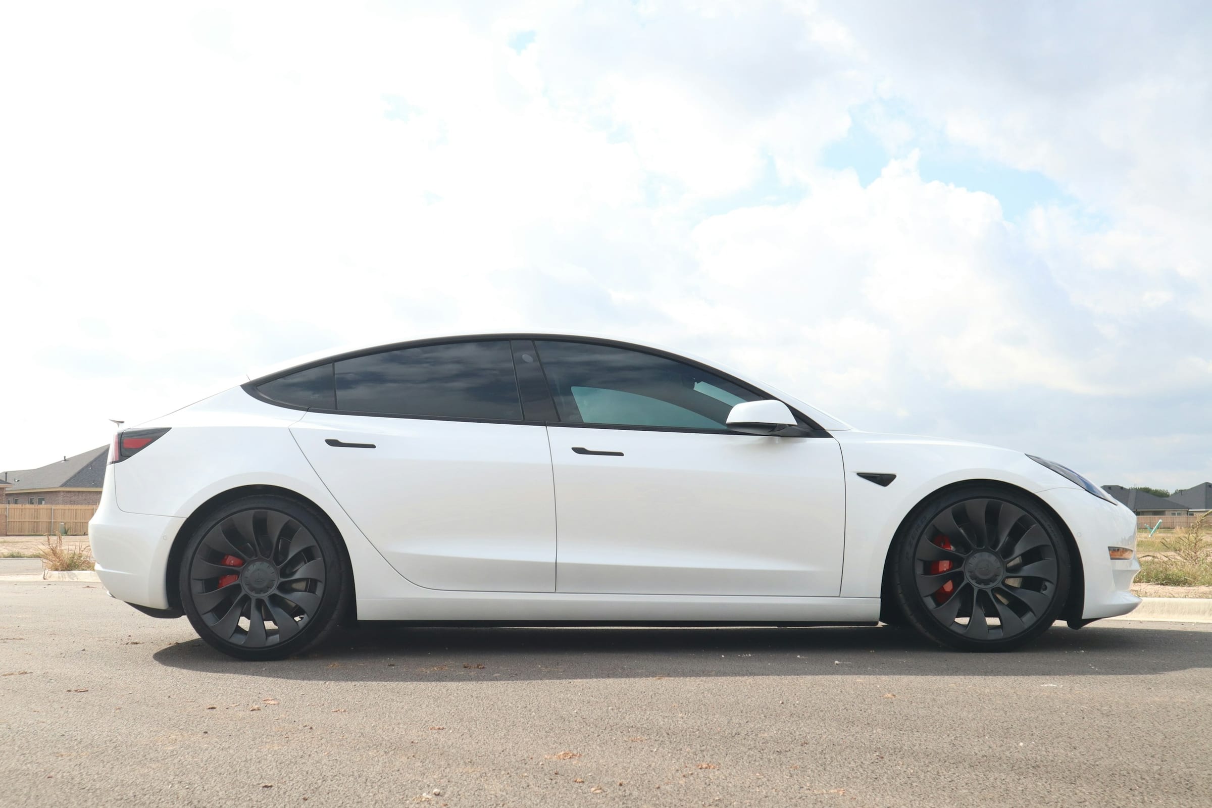 Side profile of a white Tesla Model 3